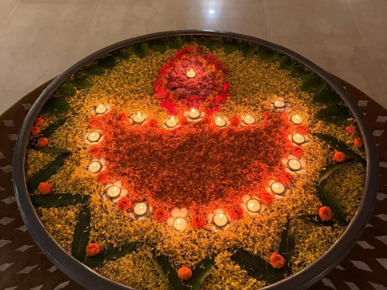 An elegant floral arrangement in a decorative urli with diyas, illuminating the entrance of Jagriti Dham, a luxurious old age home in kolkata, for Diwali.