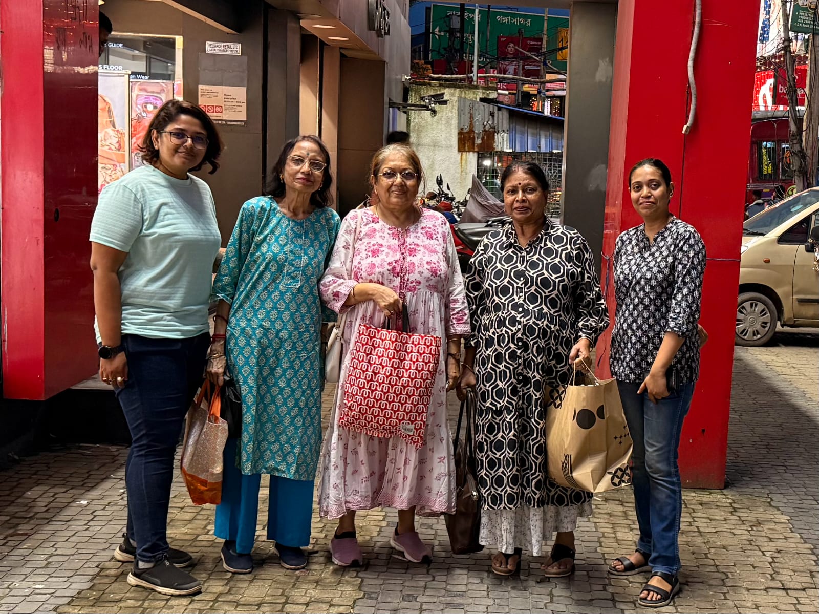 The joy of Pujo is in the air! Happy residents and staff from Jagriti Dham in Kolkata pose with their shopping bags during a festive pre-puja shopping trip.