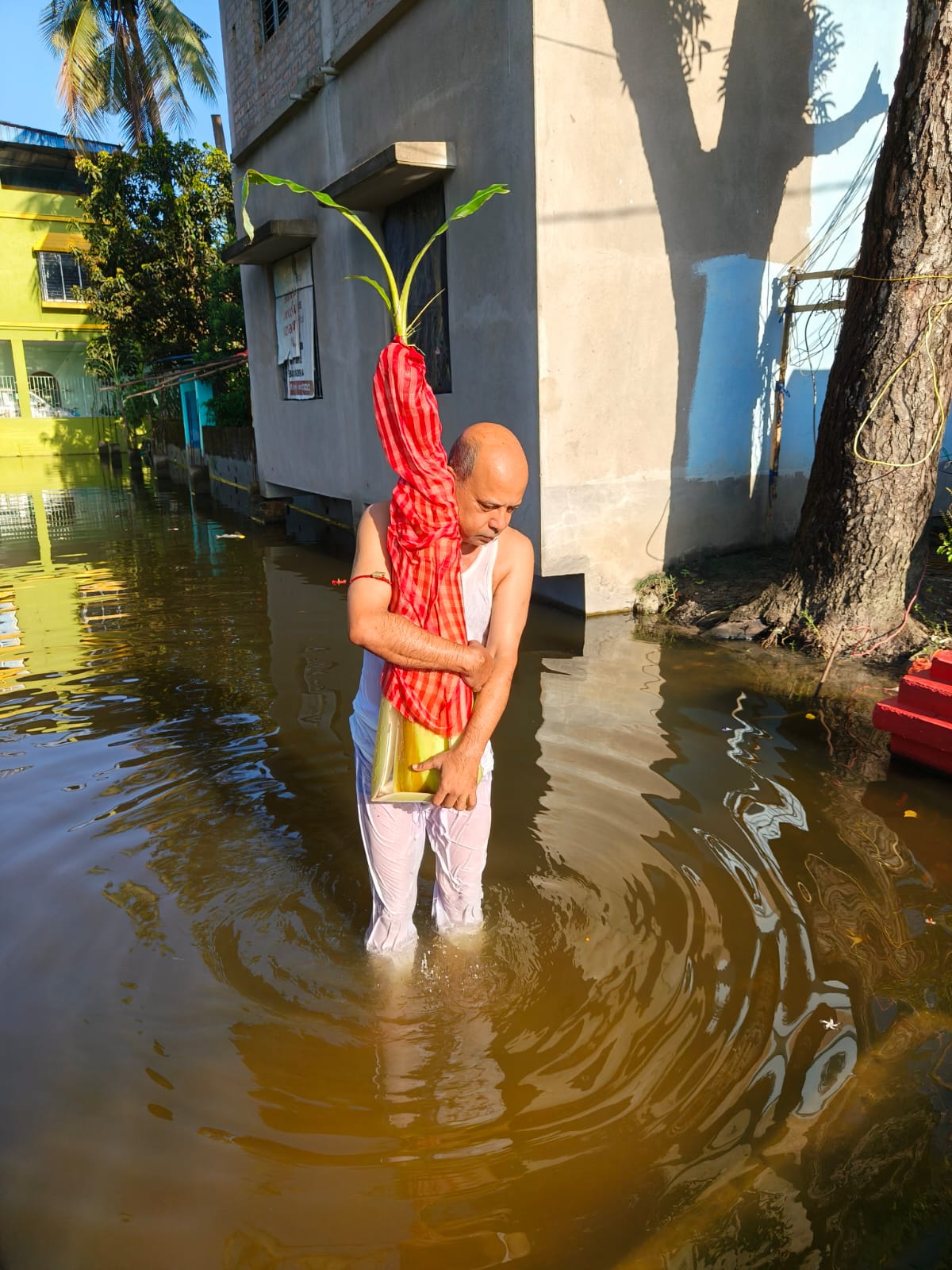 Embodying the spirit of devotion, a priest performs the Kola Bou snan for Jagriti Dham's Durga Puja, standing in high water on Saptami morning to complete the sacred ritual.