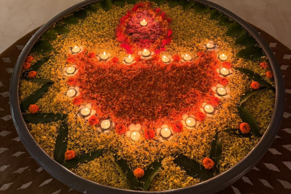 A beautiful floating flower rangoli with lit diyas creating a serene festive ambiance for Diwali at a luxurious old age home in Kolkata.