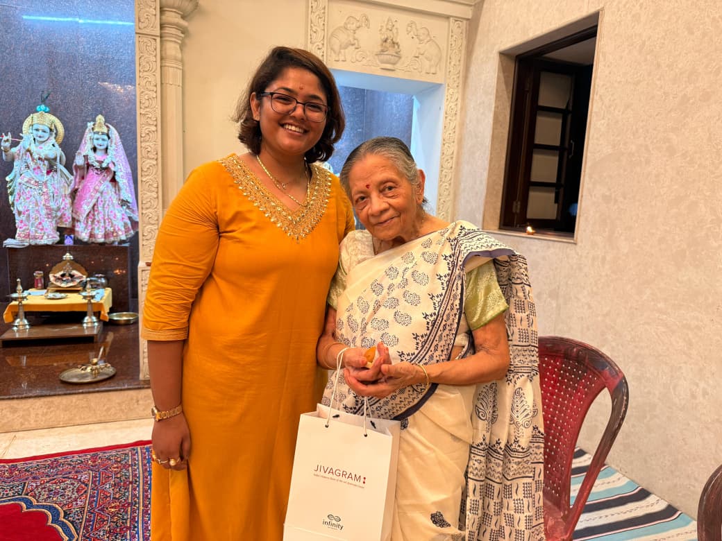 An elderly resident and a guest share a smile with a Diwali gift at the in-house temple of Jagriti Dham, a luxurious old age home in Kolkata.