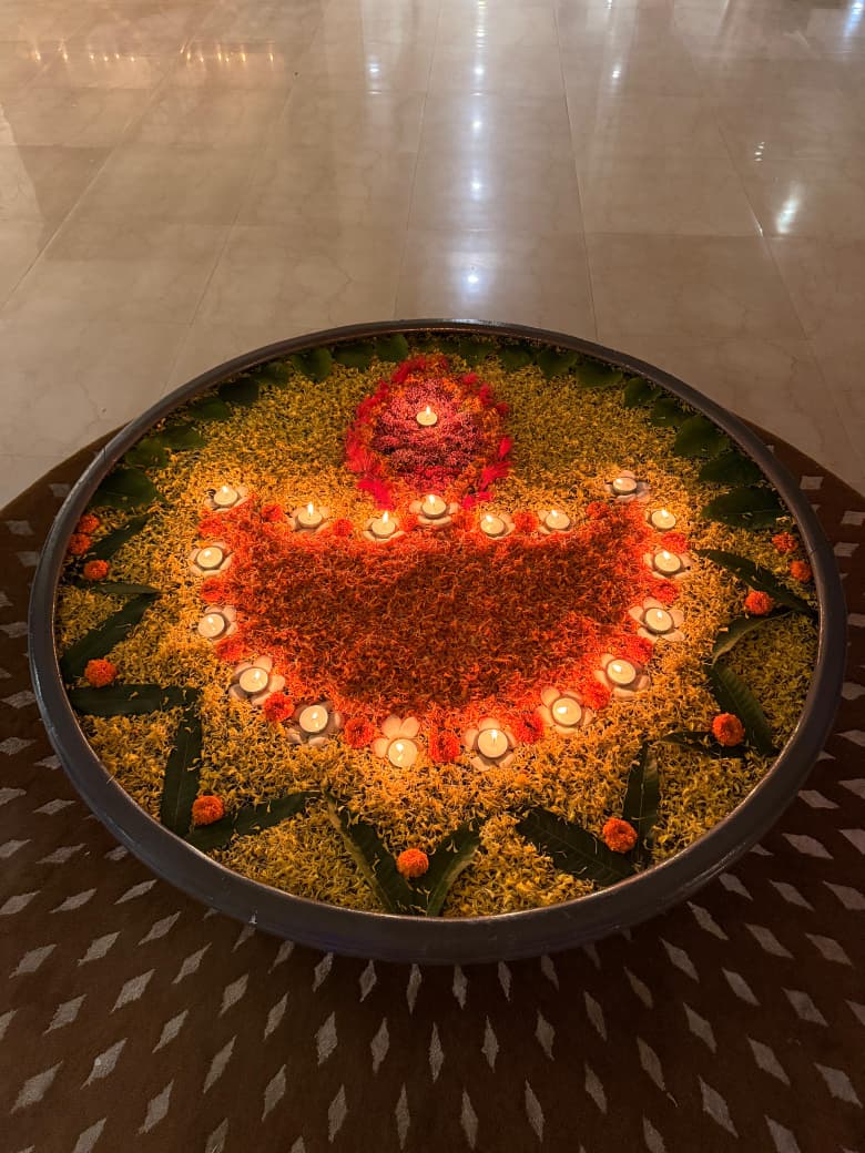 A beautiful floating flower rangoli with lit diyas creating a serene festive ambiance for Diwali at a luxurious old age home in Kolkata.