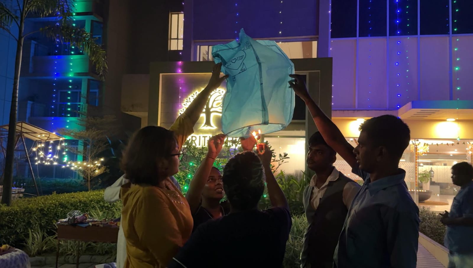 Residents and staff gather to light a traditional 'fanush' (sky lantern) during Diwali night at their luxurious old age home in Kolkata.