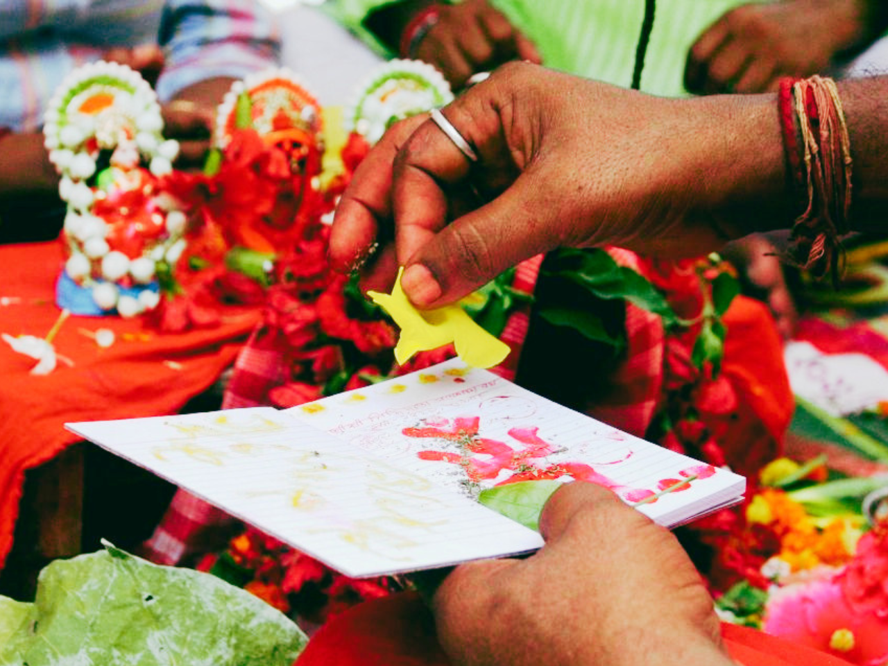 A close-up of the traditional Haal Khata ceremony, showing the sanctification of a new ledger with vermillion and flowers to mark a prosperous Bengali New Year.