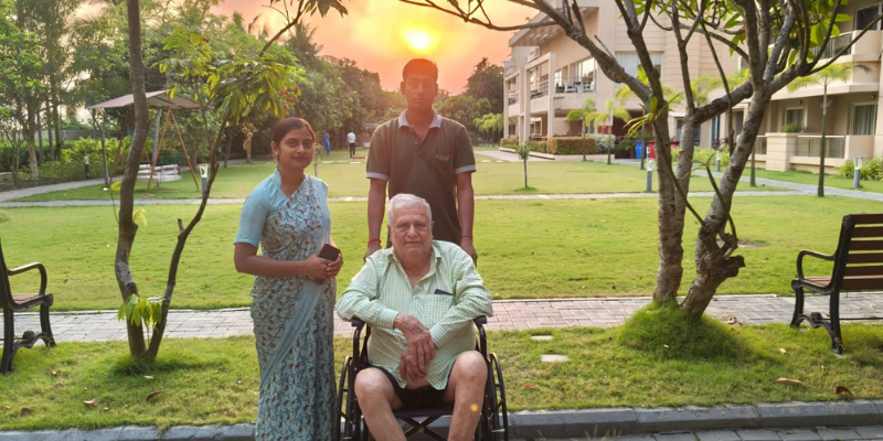 A senior resident in a wheelchair accompanied by dedicated care staff during sunset at Jagriti Dham, the premier luxurious old age home in kolkata.