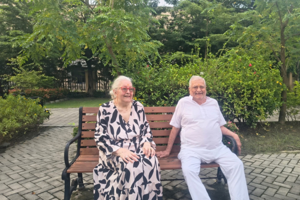 Senior couple relaxing outdoors during short term respite care at Jagriti Dham.