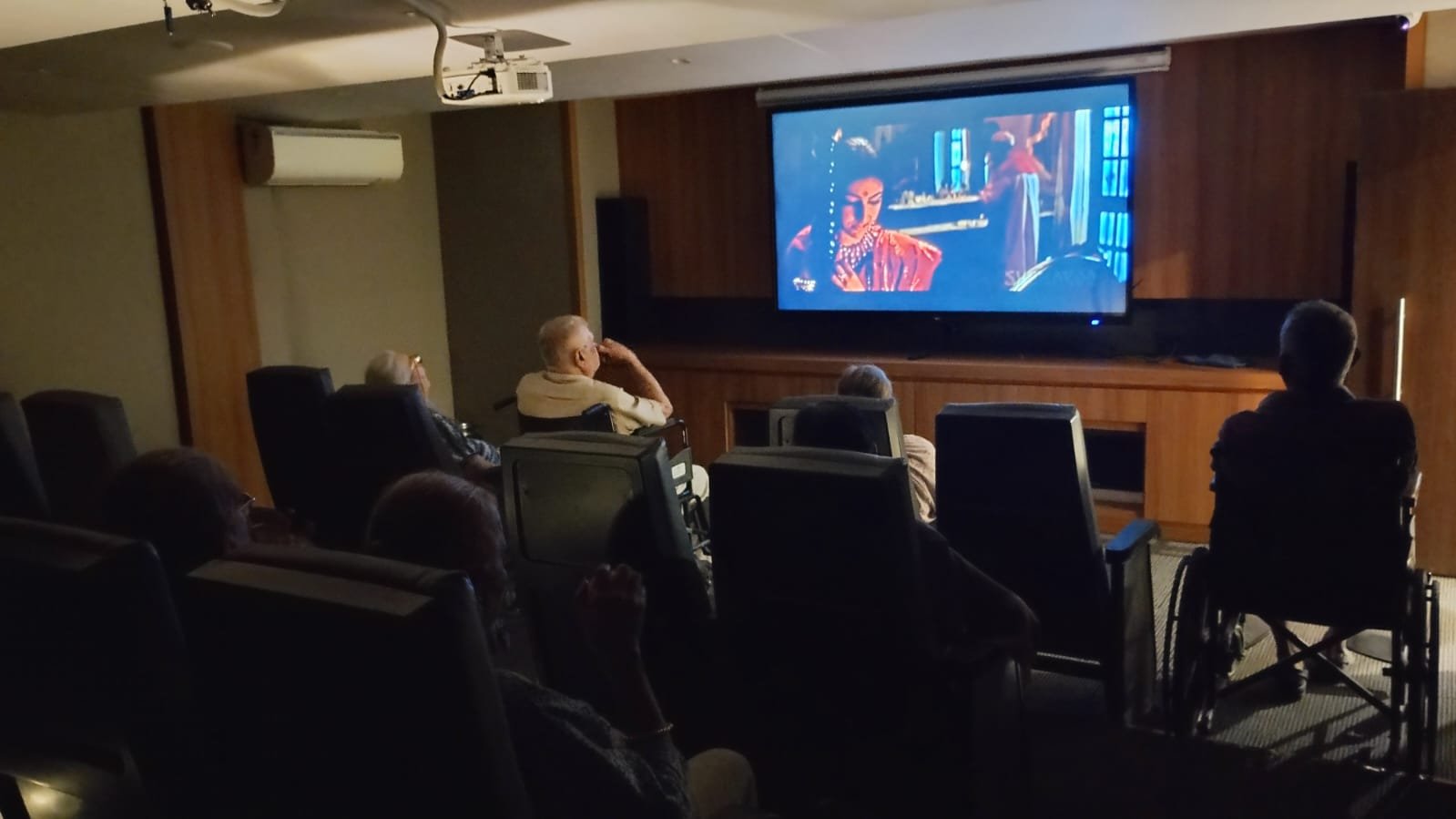 Seniors enjoying a movie together in luxury senior living facilities.
