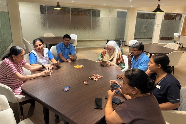 Activities for senior citizens at Jagriti Dham, where elderly residents and caregivers enjoy playing cards together.